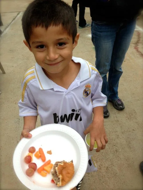 A young boy holding a plate of food at a Southwood community cookout