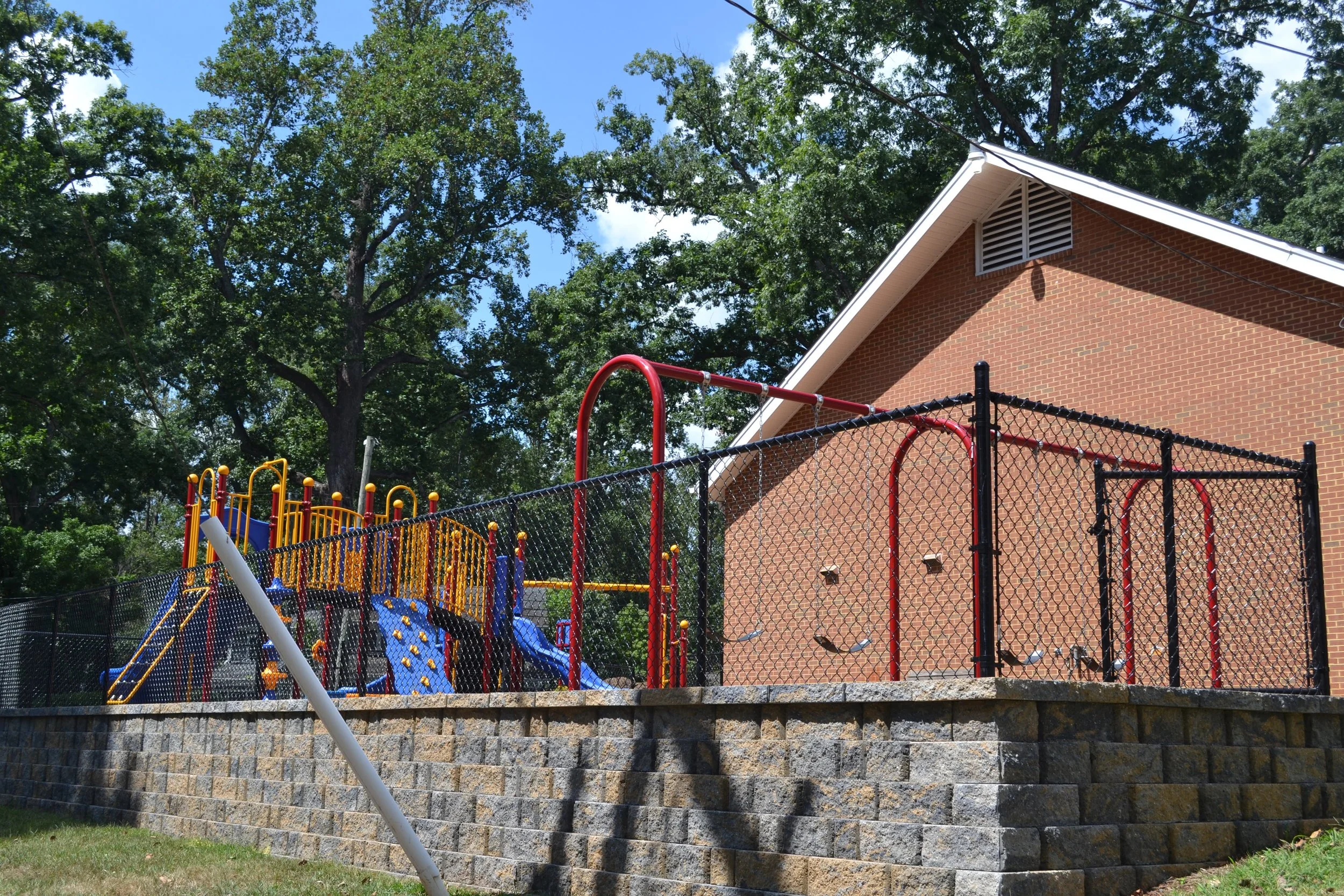 The playground beside the brick wall of the church building