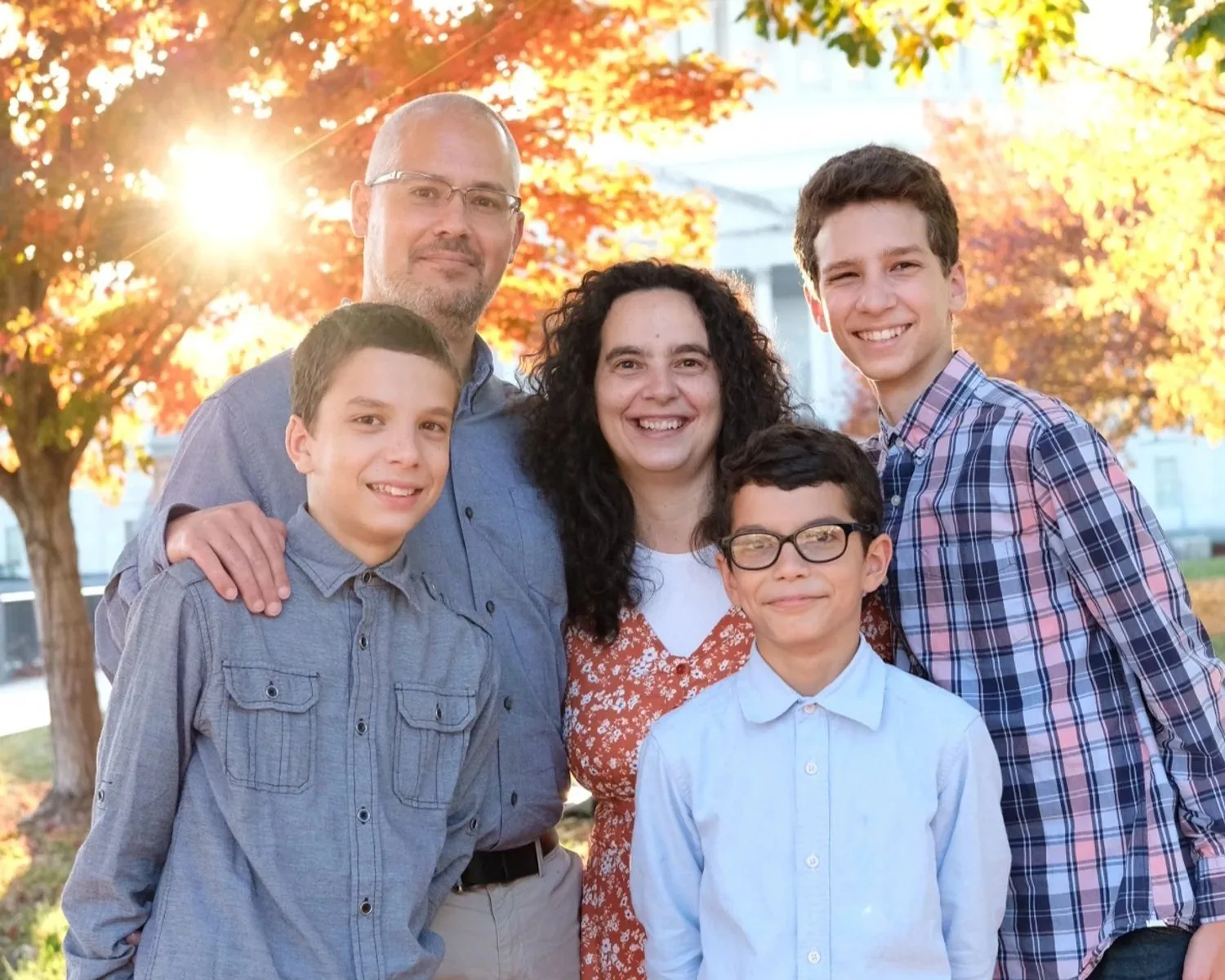 Tiago Oliveira with his wife Marta and their three sons outdoors in autumn light