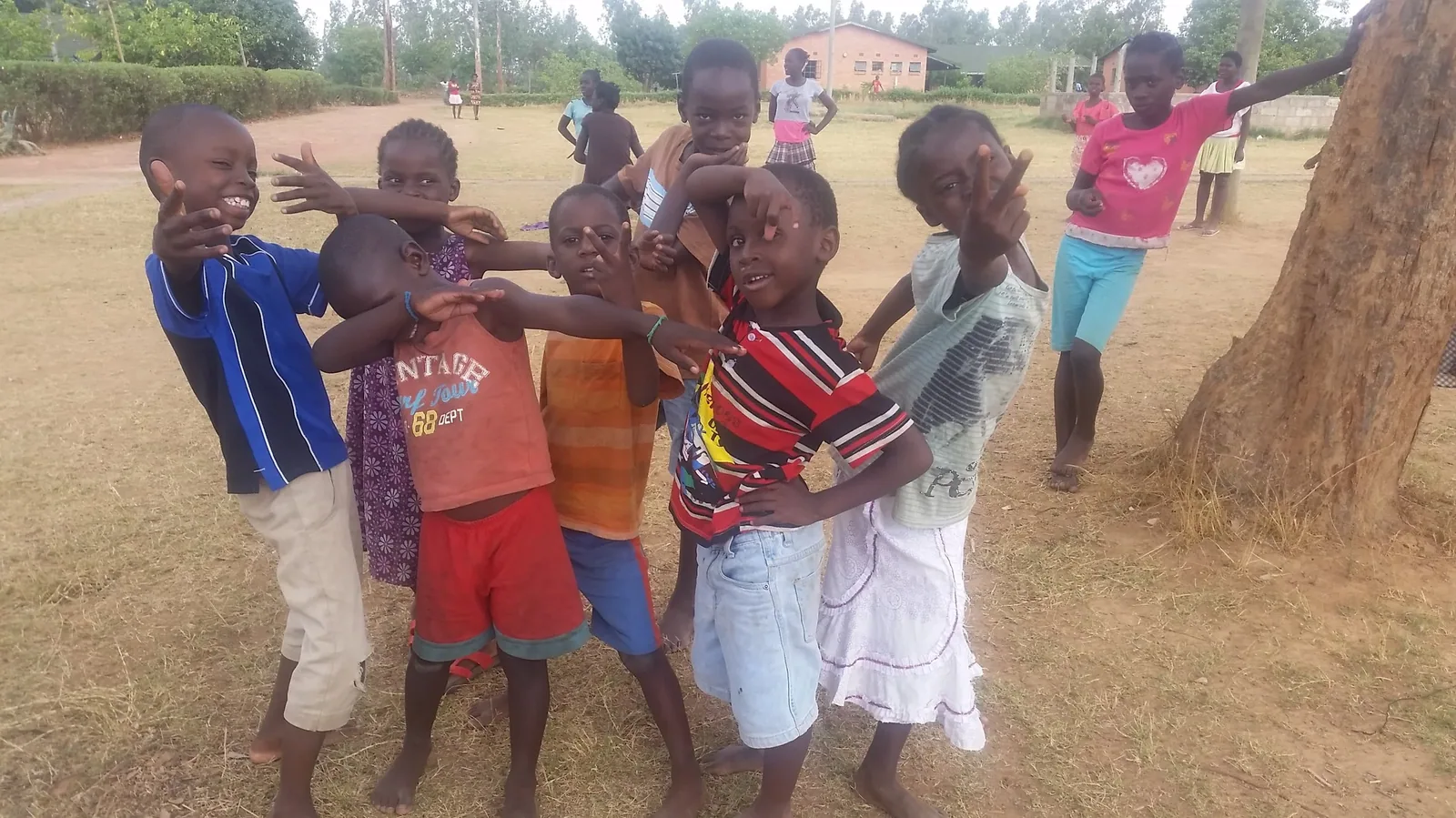 Children playing together on the dusty ground outside a Zambian church