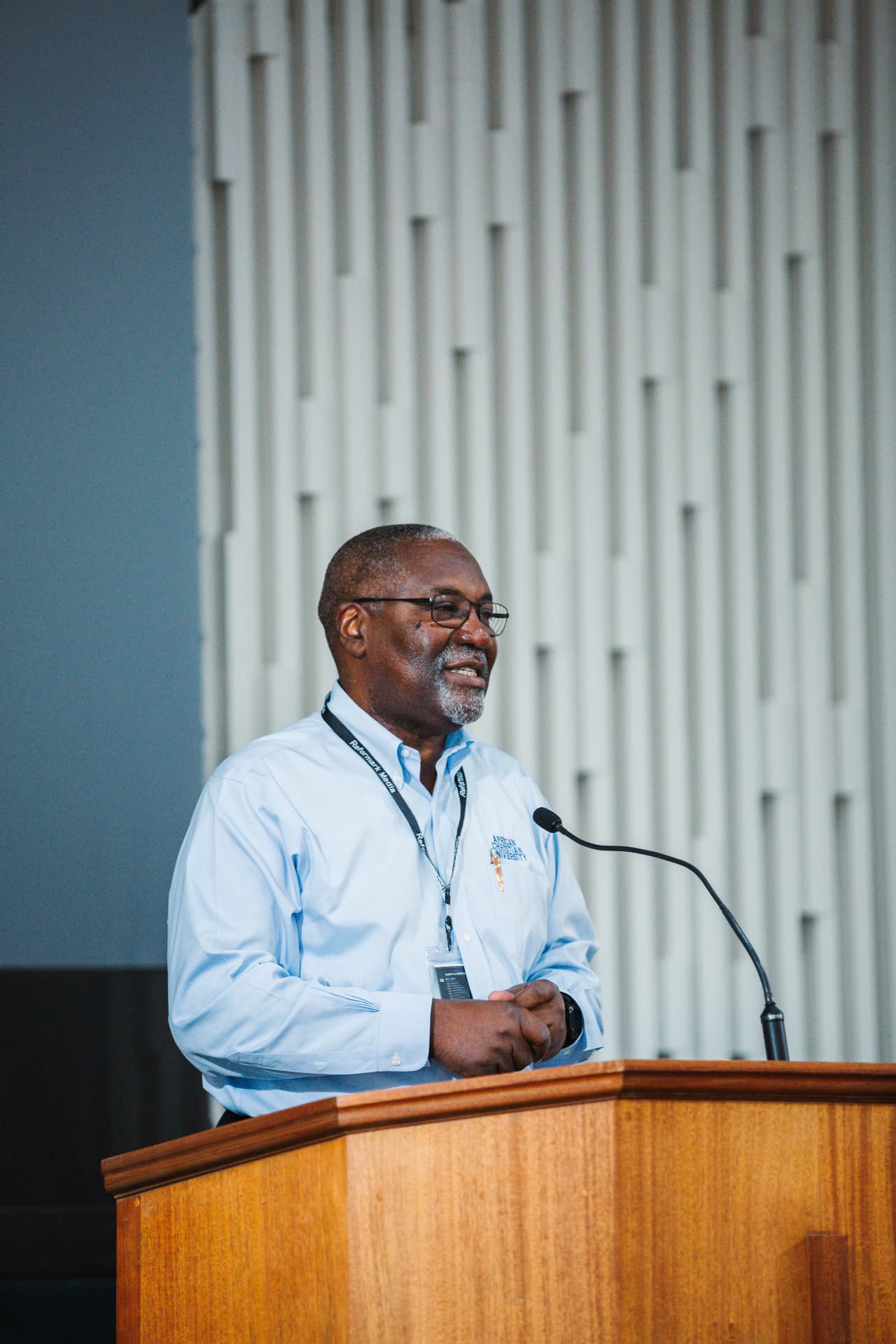 Conrad Mbewe, pastor of Kabwata Baptist Church in Lusaka, Zambia, preaching from a wooden pulpit