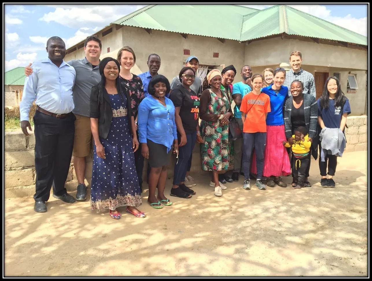 Church members and visiting JPBC members gathered outside a Zambian church building for a group photo