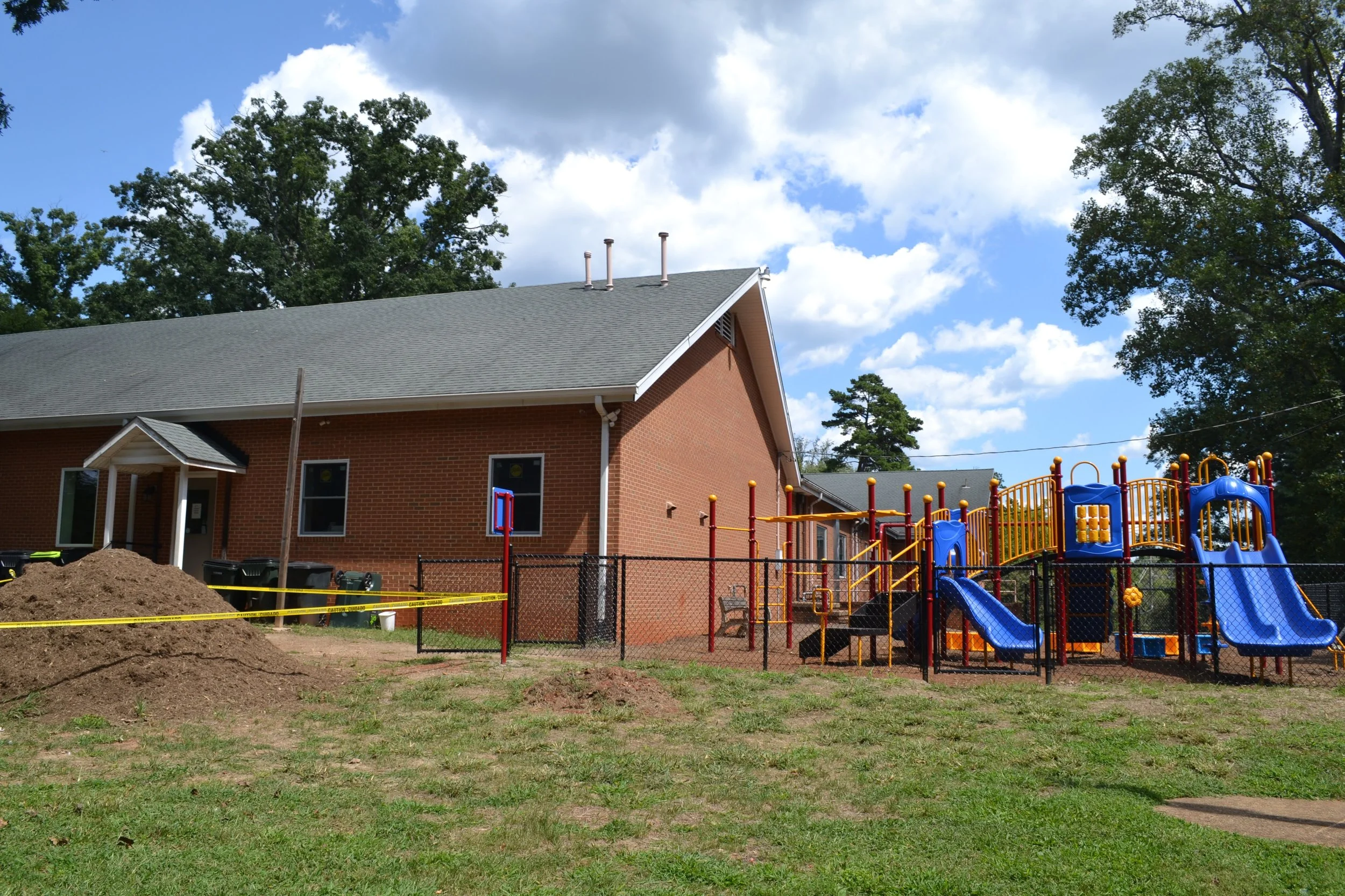 Wide view of the playground and lawn from across the churchyard