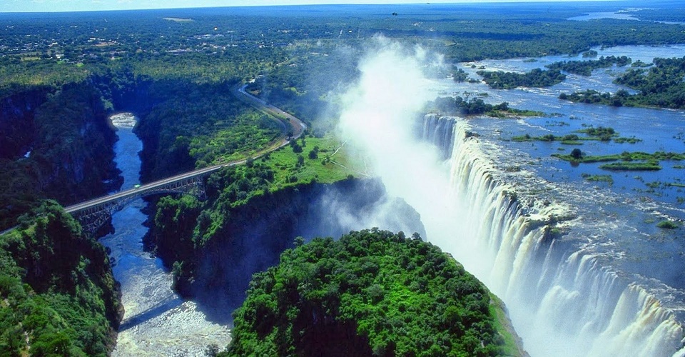 Aerial view of Victoria Falls in Zambia, water plunging into the gorge with green forest along the rim
