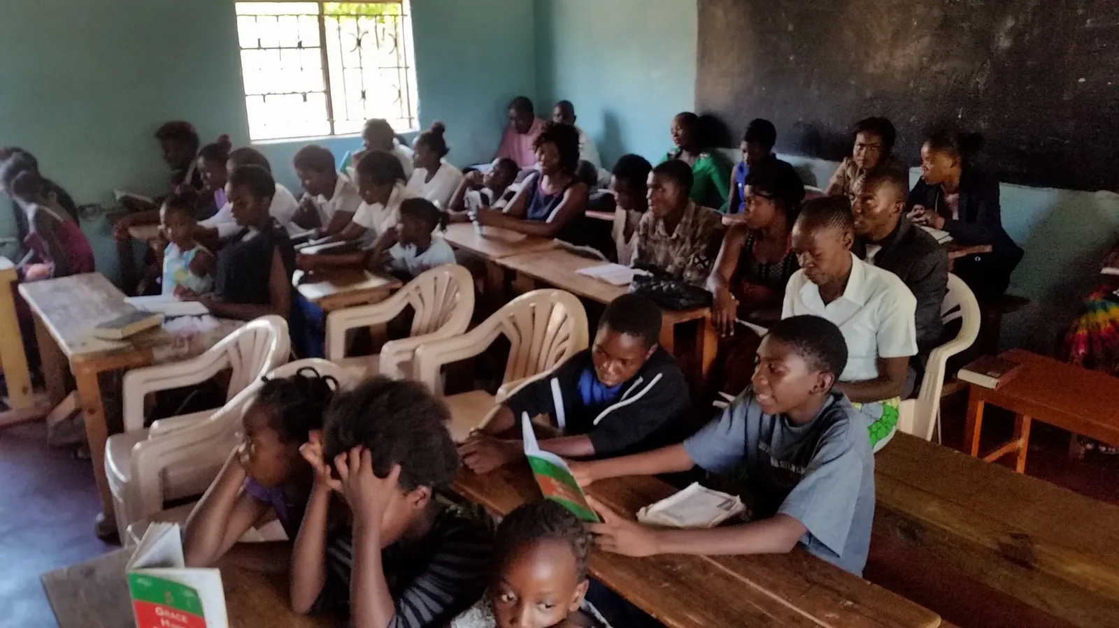 Children reading together at long tables in a church classroom