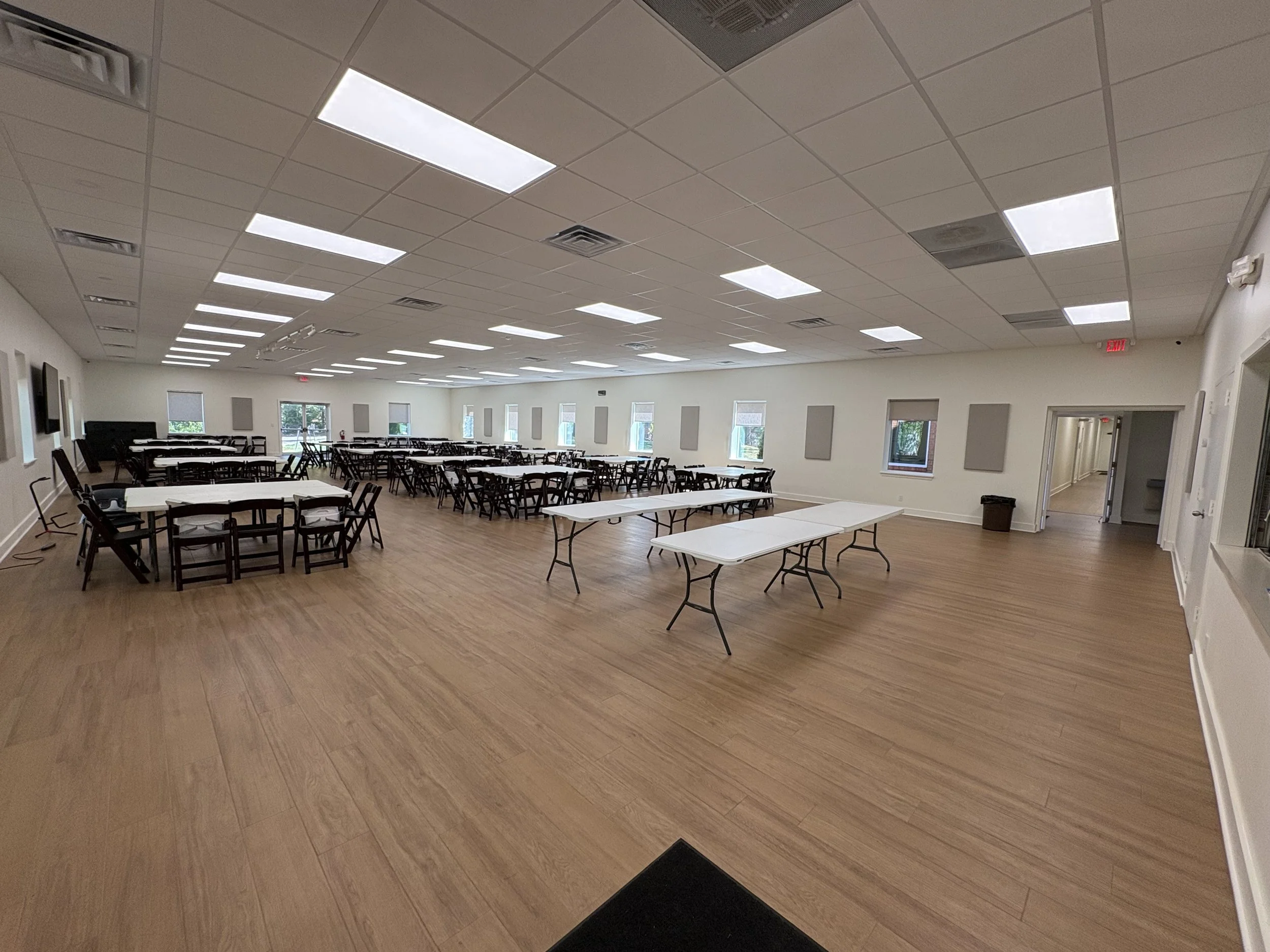 Wide view of the renovated fellowship hall with new flooring and lighting