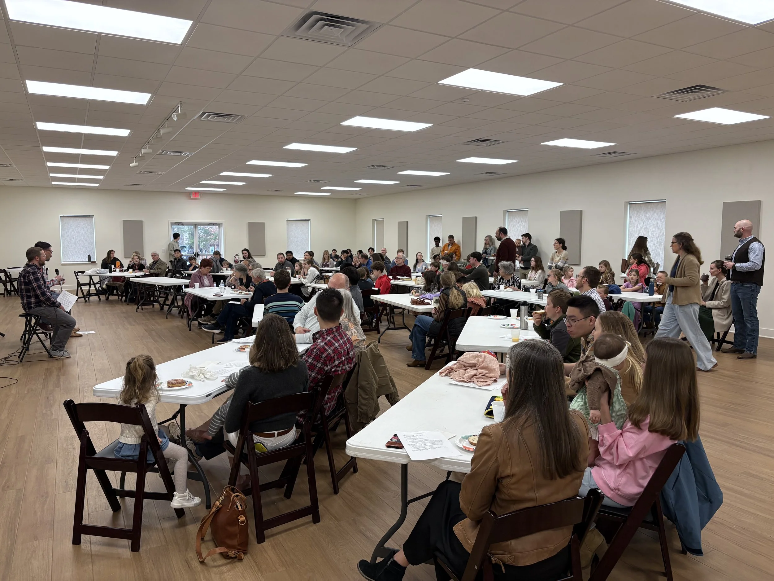 The expanded fellowship hall filled with families eating together